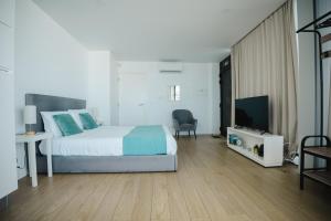 a bedroom with a bed and a flat screen tv at Casa do Horizonte in Ribeira Grande