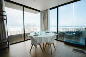 a dining room with a white table and some glass windows at Casa do Horizonte in Ribeira Grande