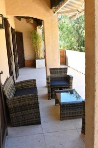 an outdoor patio with wicker chairs and a table at Résidence Gigaro plage in La Croix-Valmer
