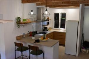 a kitchen with a white refrigerator and a counter with chairs at Résidence Gigaro plage in La Croix-Valmer