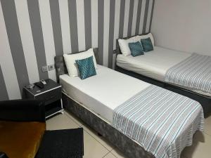 two beds in a small room with striped walls at LOTUS OTEL in Konya +18 photos