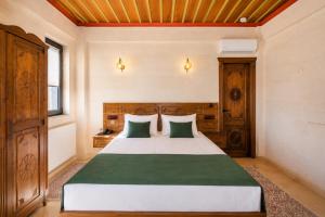 a bedroom with a bed with green and white pillows at Mai Cappadocia in Göreme