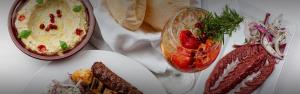 a table with two plates of food and a bowl of dip at Blue Monkey Hotel & Beach Club in Saint James