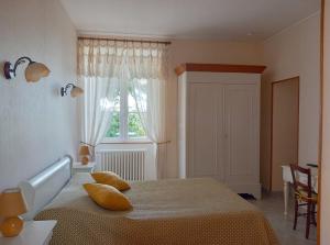 a bedroom with a bed with pillows and a window at laferme de chez Piché in Chérac