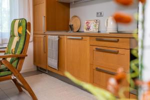 a kitchen with wooden cabinets and a chair in it at Apartma BONUS in Begunje na Gorenjskem