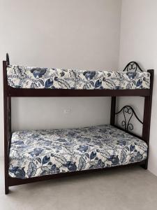 a triple bunk bed with a blue and white blanket at Maréa - Casa en Lobitos in Lobitos