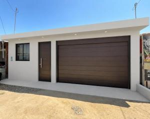 a pair of garage doors on a house at Maréa - Casa en Lobitos in Lobitos