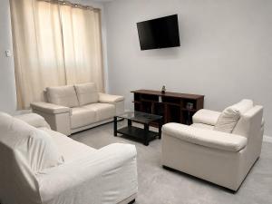 a living room with white furniture and a flat screen tv at Maréa - Casa en Lobitos in Lobitos
