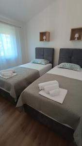 two beds sitting next to each other in a room at Apartman Tarja in Kastel Novi