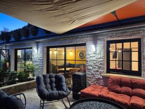 a patio with a couch and chairs and a table at Le logis de la mésanges Bleue in Gignac +13 photos