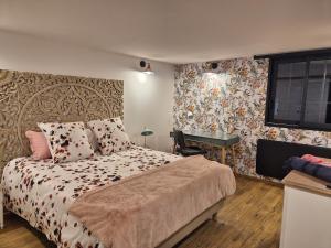 a bedroom with a bed and a desk in it at Le logis de la mésanges Bleue in Gignac