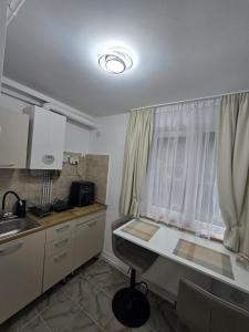 eine Küche mit Schreibtisch, Spüle und Fenster in der Unterkunft VivaVero in Baia Mare
