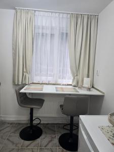 Ein Tisch und zwei Stühle vor einem Fenster in der Unterkunft VivaVero in Baia Mare