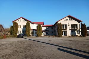 a large white house with a car parked in the driveway at Pensiunea Cionca str 1 Decembrie 1918 nr 466 in Gilău