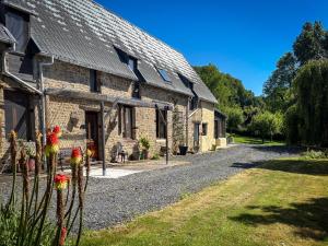 a stone house with a gravel road next to it at Le Marronnier in Montchauvet