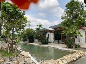 a house next to a river in front of a house at บ้านนกฮูกรีสอร์ท in Ban Chamun (2)