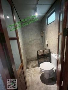 a small bathroom with a toilet and a shower at บ้านนกฮูกรีสอร์ท in Ban Chamun (2)