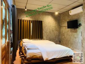 a bedroom with two beds and a television in it at บ้านนกฮูกรีสอร์ท in Ban Chamun (2)