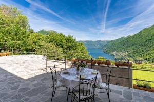 a table on a patio with a view of a lake at Incanto del Lago Country House in Faggeto Lario  +77 photos