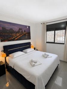 a bedroom with a large white bed with two towels on it at Kinneret Royal Penthouse in Tiberias