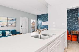 a kitchen with a sink and a white counter top at SPI Beach Condo - Just a block away to Paradise in South Padre Island +16 photos