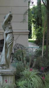 a statue next to a bench in a garden at NOBILI LIBARDI - VILLA BASEVI in Verona