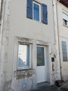 a building with a white door and windows at comfortable village house in Le Fossat