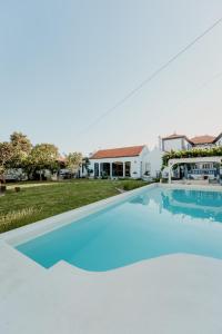 a large swimming pool in front of a house at Galricho Heritage House in Murtosa