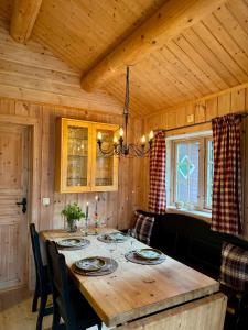 a dining room with a wooden table and chairs at Cabin in Tuddal in Hjartdal