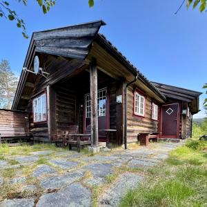 an old log cabin with red doors and windows at Cabin in Tuddal in Hjartdal