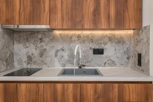 a kitchen sink with a faucet on a counter at Dionisos Resort in Pefkochori +79 photos