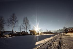 eine Sonne über einer schneebedeckten Zugstrecke in der Unterkunft Korona Karpat in Laseschtschyna