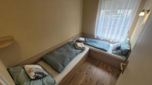 a small room with two beds and a window at Kicsi Rigó Vendégház in Bogács