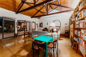 a dining room with a green table and some bookshelves at Galricho Heritage House in Murtosa