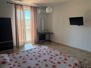a bedroom with a bed and a desk and a television at La casa di Nerone in Acireale