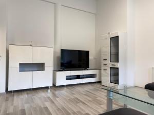 a white living room with a television and a glass table at Komfortresidenz Harmonie in Weiz +19 photos