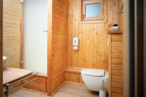 a wooden bathroom with a toilet and a window at Nature's Nest - The Woods in Maribor
