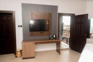 a room with a tv and a desk with a television at Muster Point Hotel & Suites in Port Harcourt +40 photos