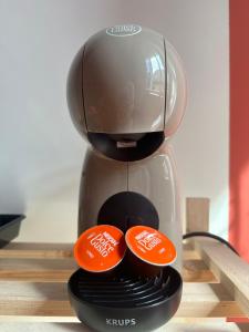 a coffee maker with two orange buttons on it at Les Suites du Quai in Montmélian