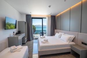 a hotel room with two beds and a television at Vila Era Beach 2 in Sarandë