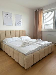 a large bed with two towels on it in a bedroom at Modra Sunny Apartment in Modra