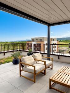 a patio with two chairs and a couch on a balcony at Modra Sunny Apartment in Modra