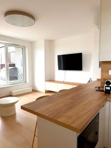 a kitchen with a kitchen island with a flat screen tv at Modra Sunny Apartment in Modra