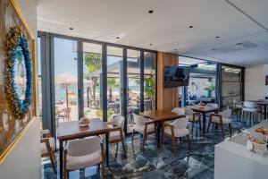 a restaurant with tables and chairs and a view of the ocean at Vila Era Beach 2 in Sarandë