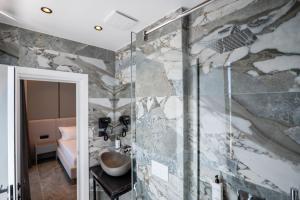 a bathroom with a sink and a glass shower at Vila Era Beach in Sarandë +237 photos