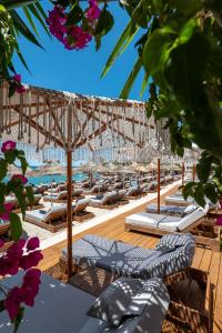 a row of lounge chairs and umbrellas on a beach at Vila Era Beach 2 in Sarandë