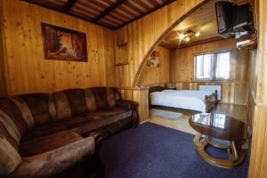 ein Wohnzimmer mit einem Sofa und einem Bett in der Unterkunft Korona Karpat in Laseschtschyna