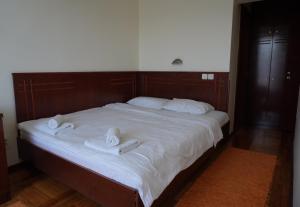a large bed with two white towels on it at Konačište Compass in Kraljevo
