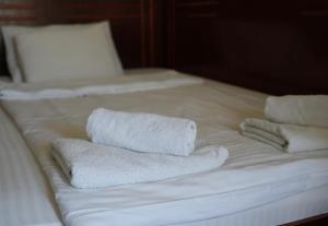 a group of towels sitting on a bed at Konačište Compass in Kraljevo