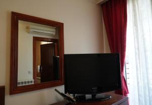 a television sitting on a table in front of a mirror at Konačište Compass in Kraljevo